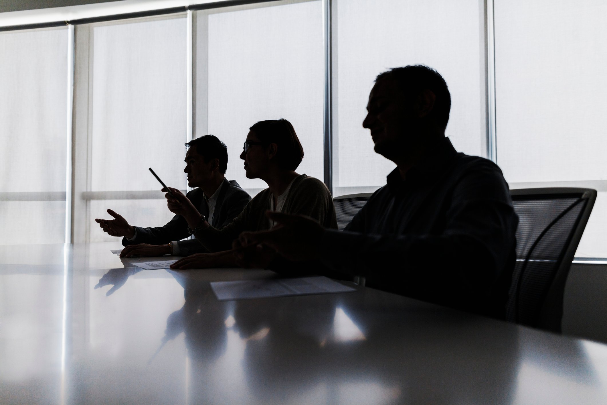 Silhouette of insurers negotiating a med-malpractice case at a meeting table